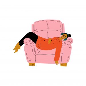 woman in a pink armchair listening with headphones